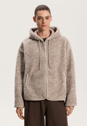 Braune, flauschige Kapuzenjacke mit Reißverschluss, Fronttaschen und Kordelzügen. Texturiertes Material mit kontrastierenden beigen Kanten und Akzenten.
