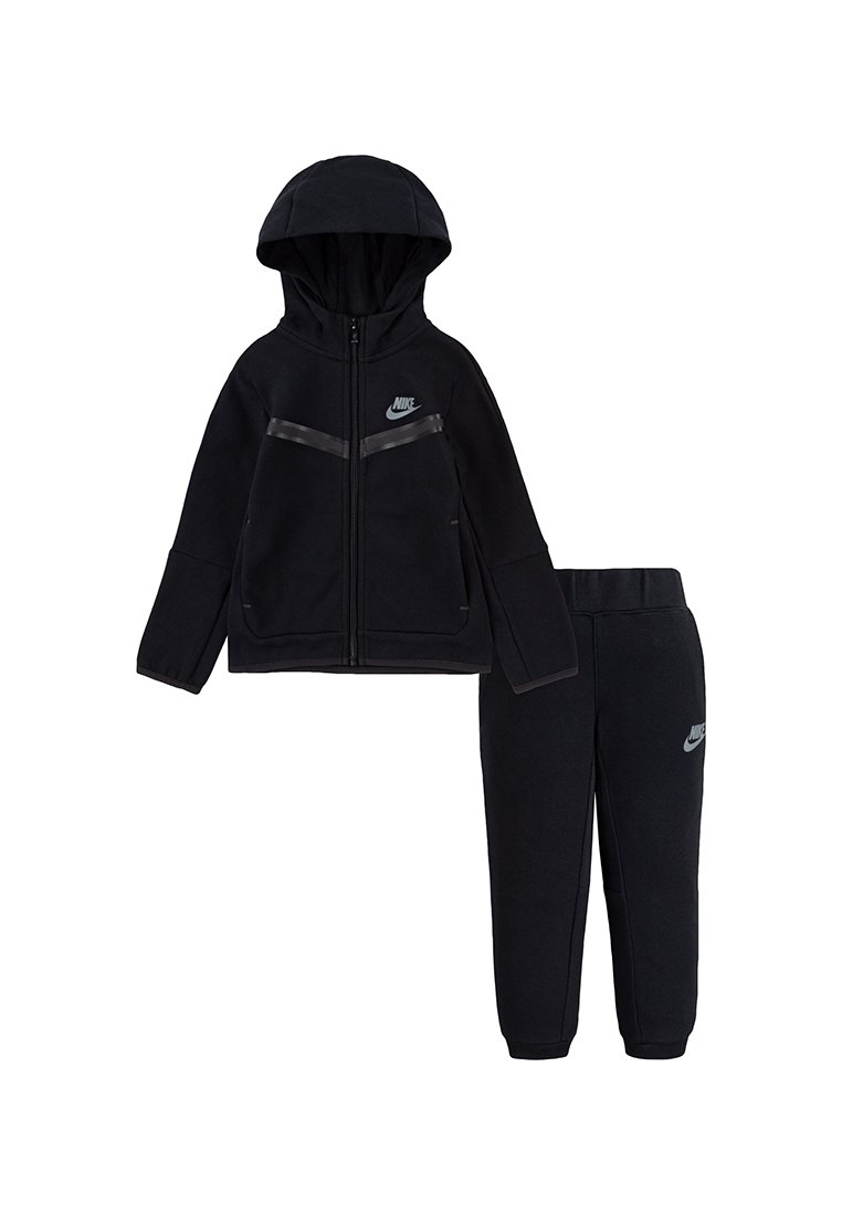 Survêtement en polaire noir avec une veste à capuche zippée et un pantalon assorti. Présente un logo Nike subtil et des détails texturés sur la veste.