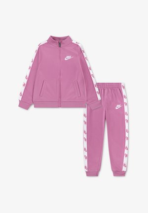 Rózsaszín Nike melegítő, cipzáros dzsekivel oldalzsebekkel és gumis derekú nadrággal. Mindkét darabon fehér, márkás oldalsávok találhatók.