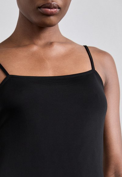 Top negru din camisole cu bretele subțiri, realizat dintr-un material neted, având un design simplu și o formă ajustată, subliniind un aspect minimalist.