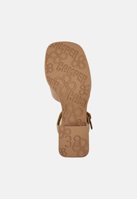 Kellon pohja, jossa on painettu "CAMPE" ja kukkakuviot, suorakaiteen muotoinen, koko 38 -merkintä. Kestävä materiaali, jossa on sileä pinta.