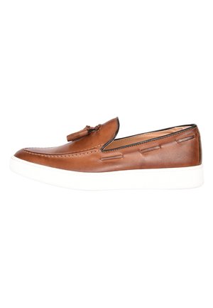 Scarpa slip-on in pelle marrone con una finitura liscia, dettagli di cucitura e suola in gomma bianca. Presenta un nappino decorativo nella parte anteriore.