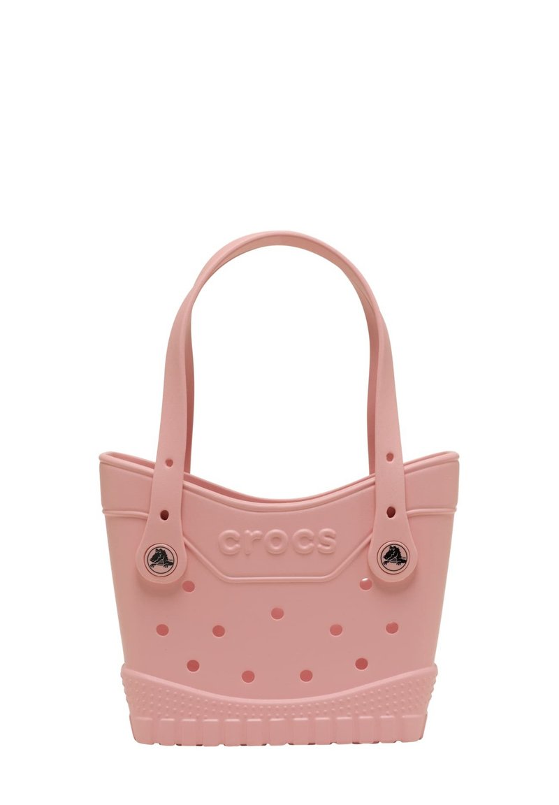 Roze plastic tote bag met afgeronde bovenkant, twee handvaten, geperforeerd lichaam en een tekstuurbasis. Bevat het "CROCS"-logo en ronde accenten.