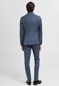 Hellblaues Anzug mit strukturiertem Schnitt, ausgestattet mit geknöpftem Revers, einem Schlitz und flachen Hosen. Glatter Stoff mit dezentem Glanz.