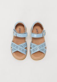 Sandales en cuir verni bleu clair avec des motifs floraux découpés, sangle réglable et semelle en cuir naturel. Semelle plate, couture décorative.