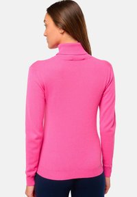 Rosa Rollkragenpullover aus weichem Strickstoff; mit langen Ärmeln, tailliertem Design, geripptem Halsausschnitt und Saum sowie glatter Textur.