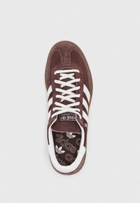 Sneaker in camoscio marrone con design a tre strisce bianche, lacci bianchi e suola in gomma. Presenta una soletta brandizzata con motivo logo.