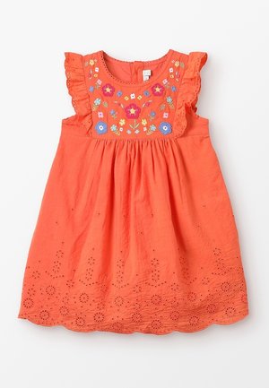 Pomarańczowa sukienka z falbanami na ramionach, kwiatowym haftem na gorsecie oraz ażurowymi zdobieniami wzdłuż dołu. Lekki materiał, luźny krój.