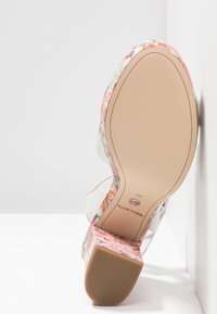 Vue de la semelle d'une sandale à talon haut à motif floral avec un talon bloc et une semelle en cuir beige, taille 37.