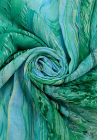 Tessuto verde a motivo, caratterizzato da una miscela di tonalità chiare e scure di verde con accenti blu. La trama appare morbida e leggera.