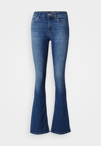Jean en denim bleu avec poches avant, fermeture par bouton et zip, jambes évasées, présenté sur un fond blanc uni.