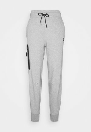 Grijze sweatpants van zachte stof met een tailleband met trekkoord, taps toelopende pijpen, zijzak met rits en een logo-accent aan de voorkant.