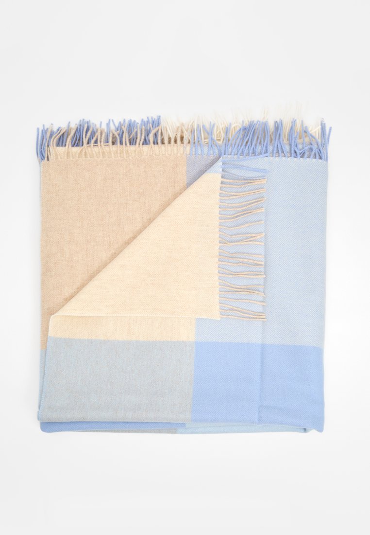 Wolldecke in Beige und Hellblau mit geometrischem Muster. Fertig gesäumte Kanten mit Fransen. Weiche Textur, ordentlich gefaltet.