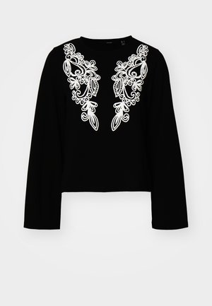 Melnas ilgas piedurknes īsa augšdaļa ar sarežģītu baltu ziedu izšuvumu priekšpusē, apaļa kakla izgriezums un gluda tekstūra.