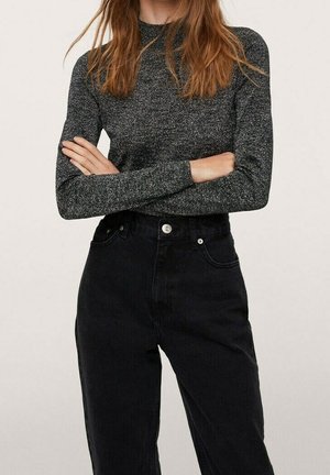 Jeans neri a vita alta abbinati a un top attillato a maniche lunghe grigio scuro con un motivo testurizzato e maculato. Dettagli con bottoni semplici visibili.