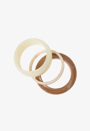 Tre runde armbånd i creme, lyse beige og brune toner, der overlapper hinanden på en hvid baggrund.