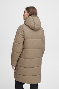 Manteau long en duvet de couleur marron clair, doté d'une capuche, avec des sections de matelassage horizontal et une surface lisse, légèrement brillante.