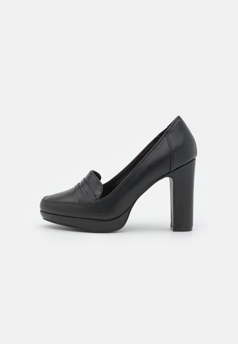 Mocassin en cuir noir à talon haut avec semelle plateforme et bout arrondi, présenté de côté sur fond blanc.