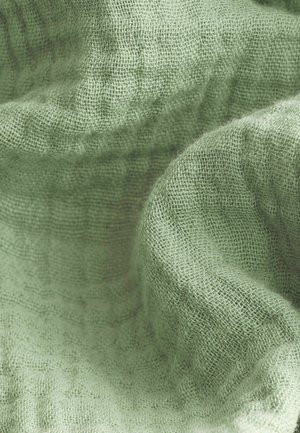 Light green textured fabric with a woven pattern, displaying a soft finish and slight sheen, draped to showcase its folds and surface.