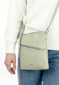 Borsa a tracolla in pelle verde chiaro con superficie texturizzata, dotata di due scomparti con zip e una tracolla regolabile.