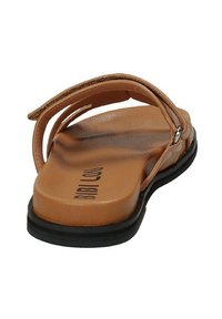 Chanclas de plástico sintético en color marrón, con dos correas, suela plana y un leve tacón. Suela exterior de goma negra, con el nombre de la marca en relieve.