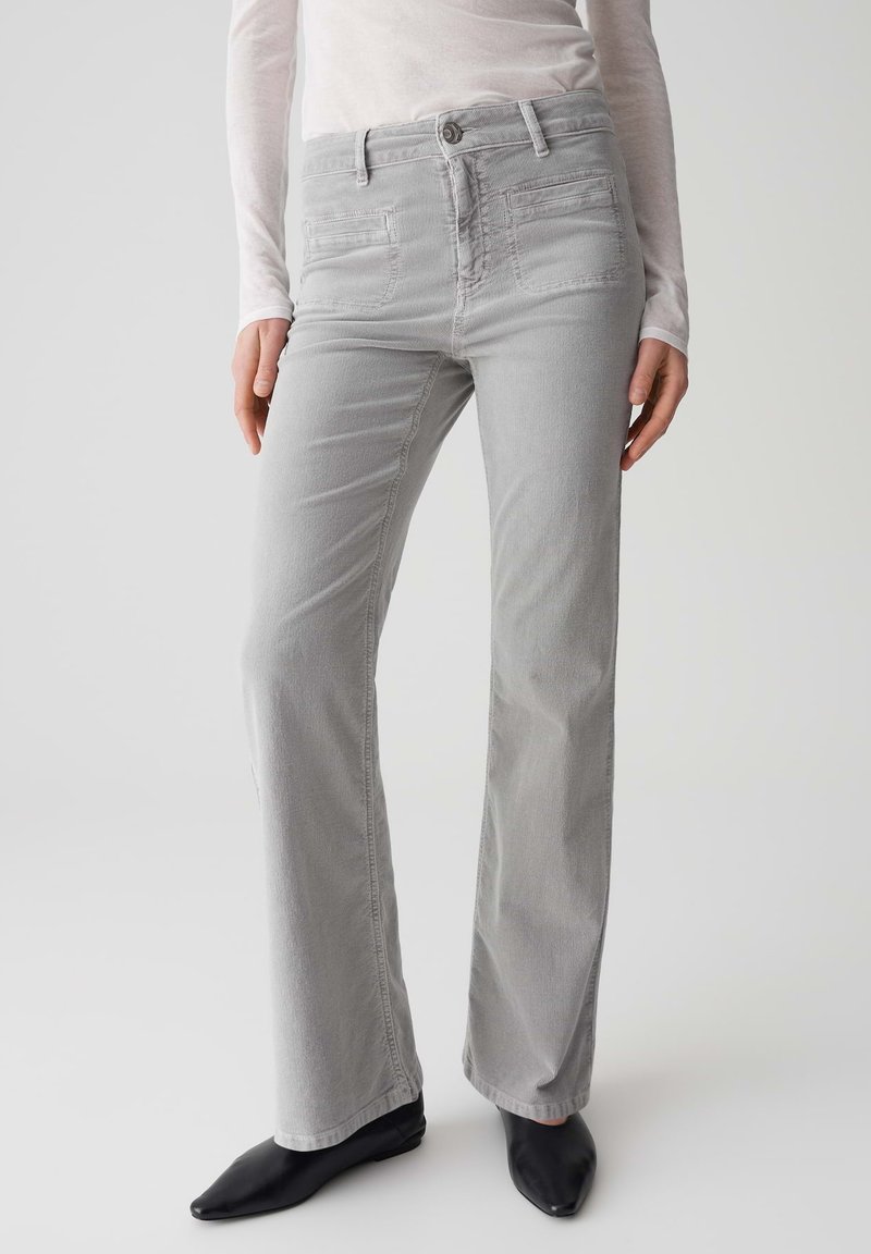 Lichtgrijze flared jeans met een gladde textuur, voorzien van voor- en achterzakken, knoopsluiting en stikseldetails.