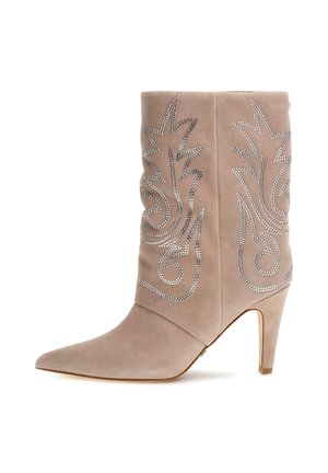 Beige suede ankle boot with pointed toe and 3.5-inch stiletto heel. Features intricate silver rhinestone designs on the outer side.