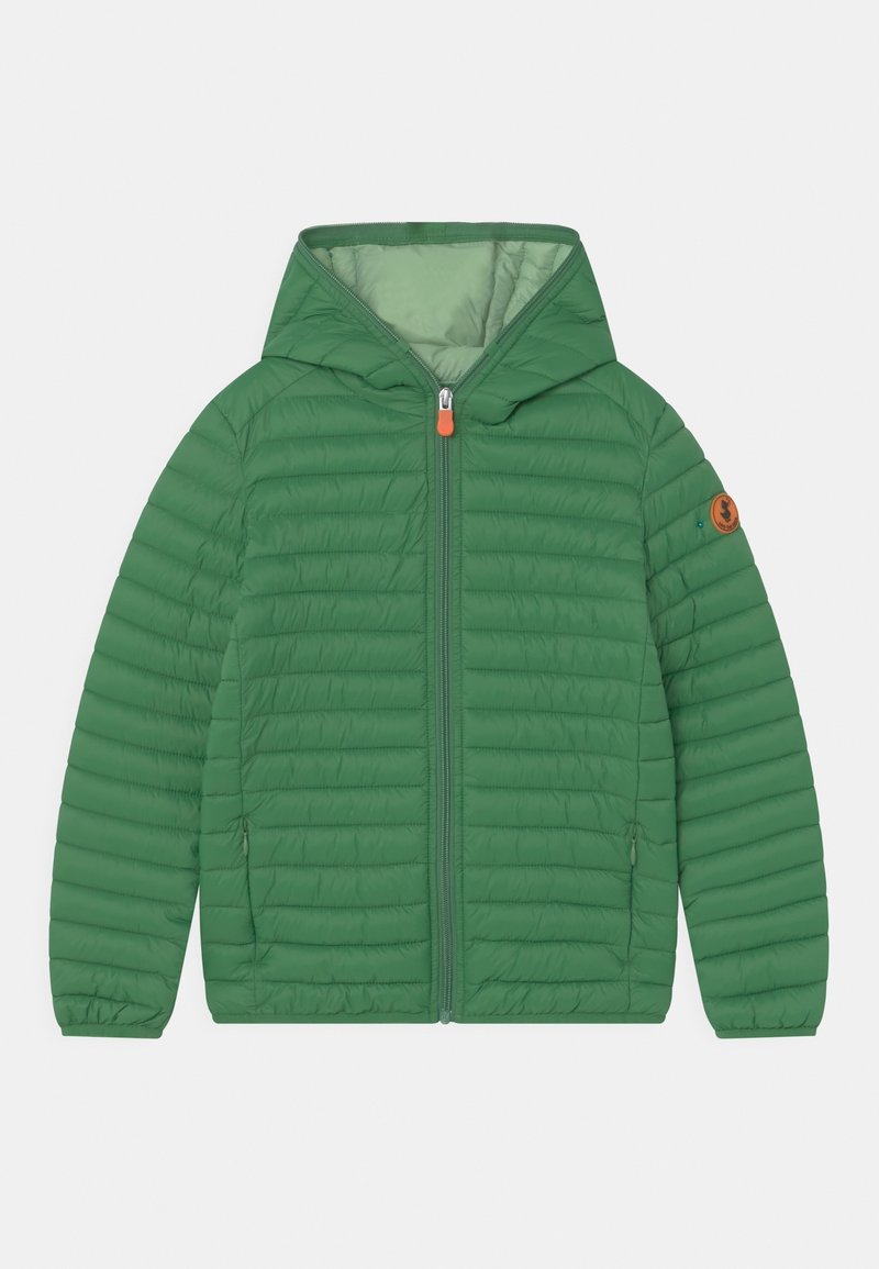 Veste matelassée légère verte avec capuche, fermeture éclair à l'avant, deux poches latérales zippées et un patch logo rond sur la manche gauche.