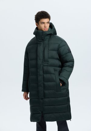 Giacca a vento verde scuro con collo alto, motivo trapuntato orizzontale, chiusura frontale con zip e tasche laterali. Materiale liscio e lucido.