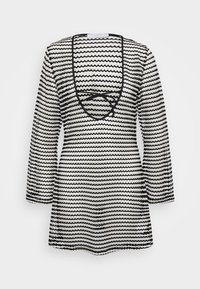 Túnica de patrón en blanco y negro con mangas largas, que presenta un diseño de rayas onduladas y un escote en V profundo con detalle de lazada en la parte posterior.