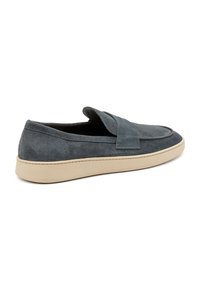 Scarpe slip-on in suede grigio con punta tonda e suola in gomma beige. Presentano una fascia decorativa sulla parte superiore. Texture morbida.