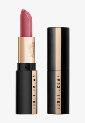 Matte mauve-rosa Bobbi Brown leppestift med gull- og svart forpakning, vist åpen og lukket mot hvit bakgrunn.