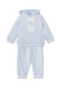 Conjunto de sudadera azul claro y pantalones a juego, hecho de una tela suave. La sudadera presenta un bolsillo frontal y rayas texturizadas con detalles del logo.