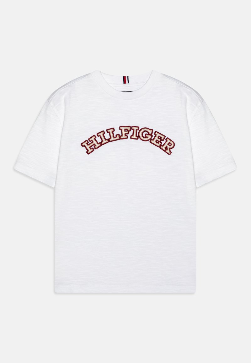 Camiseta blanca de manga corta con "HILFIGER" en letras rojas en arco y en negrita en el pecho; hecha de algodón suave con un corte relajado.