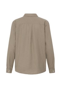 Chemise beige à manches longues avec poignets boutonnés et empiècement plissé sur le haut du dos, vue de dos sur fond blanc.