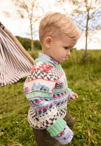 Knit sweater with a multicolored design featuring cars and geometric patterns. Light green collar, soft texture, worn over a blue shirt.