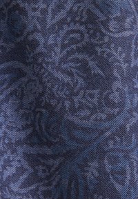 Tissu bleu foncé avec un motif floral et cachemire subtil et complexe tissé dans la texture.