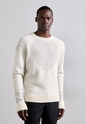 White knitted sweater with textured pattern, ribbed cuffs, and hem. Features a heart shape design with subtle gray accents on shoulders.