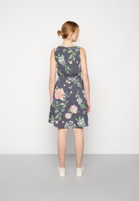 Vestido floral sem mangas em azul marinho escuro, apresentando grandes estampas de rosas em rosa e verde, um cinto na cintura e um design de saia evasê.