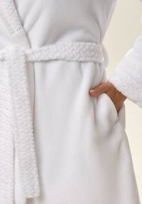 Biały frotte szlafrok z teksturowanym kołnierzem i paskiem, z kieszenią po boku. Miękki, pluszowy materiał o gładkim wykończeniu.