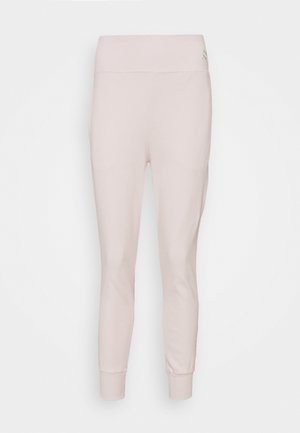 Lichtroze fitted broek gemaakt van zachte stof, met een brede tailleband en taps toelopende enkels. Subtiele steekdetails overal.