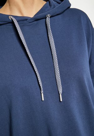 Felpa con cappuccio blu navy a superficie texturizzata, con lacci bianchi e blu navy dotati di estremità in metallo. Design semplice senza motivi.