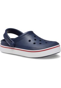 Crocs bleu marine avec une tige texturée, des trous de ventilation, une sangle arrière de soutien et une semelle blanche avec des rayures rouges et blanches.