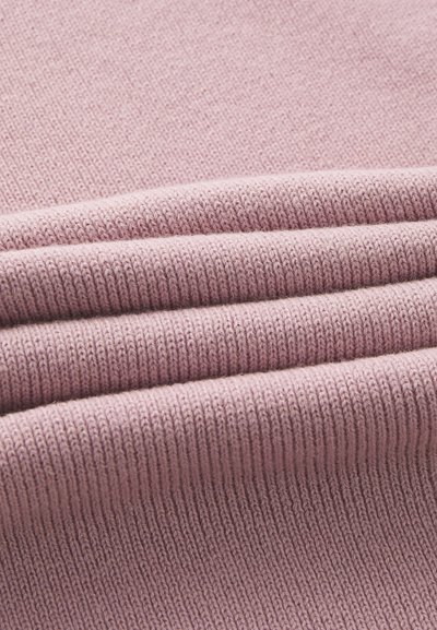 Tessuto morbido a maglia rigata di colore rosa chiaro, caratterizzato da molteplici pieghe che ne esaltano la texture e la profondità. Finitura liscia su tutta la superficie.