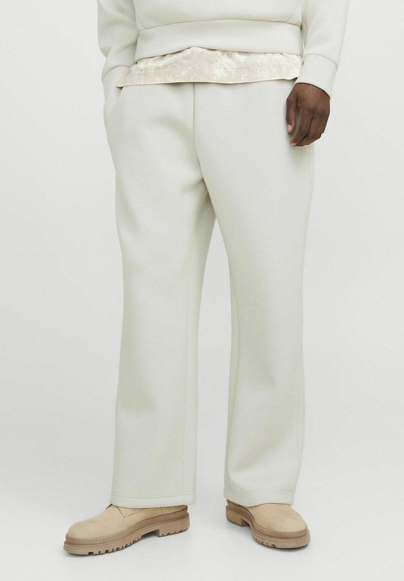 Pantaloni albi, cu croi drept, dintr-o țesătură moale, cu buzunare laterale și un luciu subtil. Asortați cu pantofi bej, texturat.