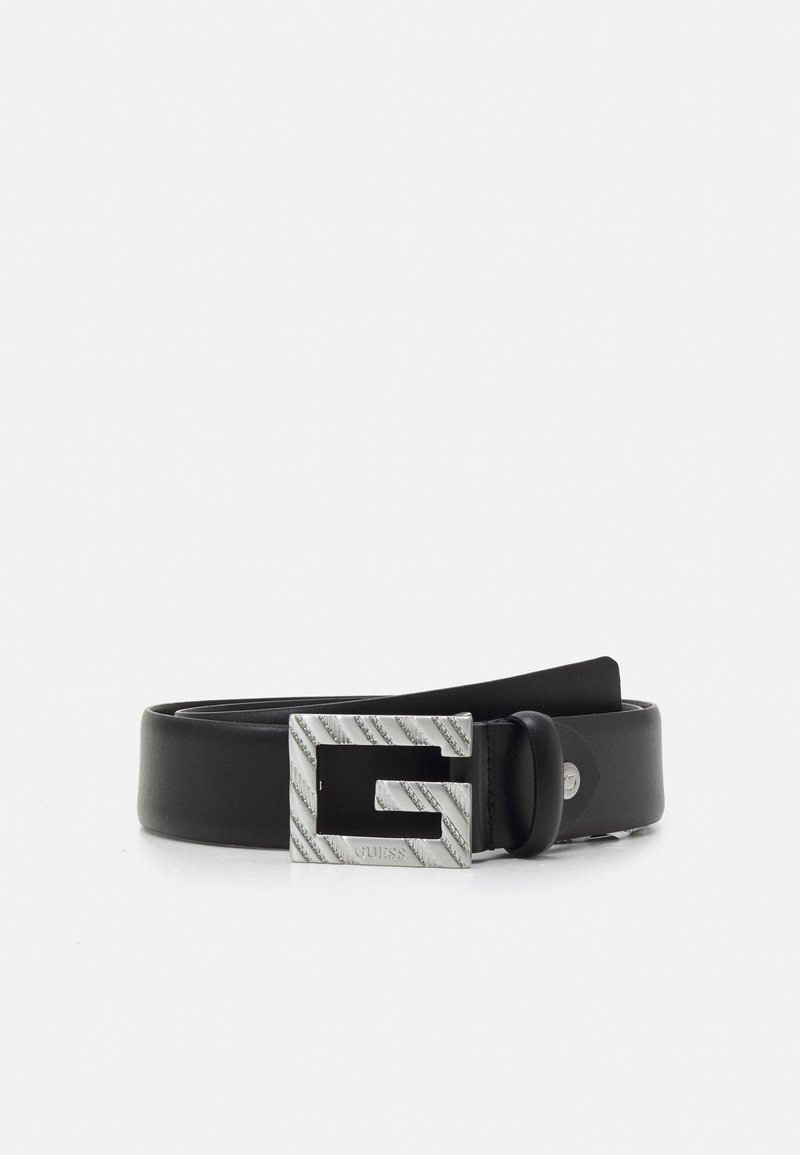 Ceinture en cuir noir avec une grande boucle argentée en forme de "G" avec des rayures diagonales et le mot "GUESS" gravé.