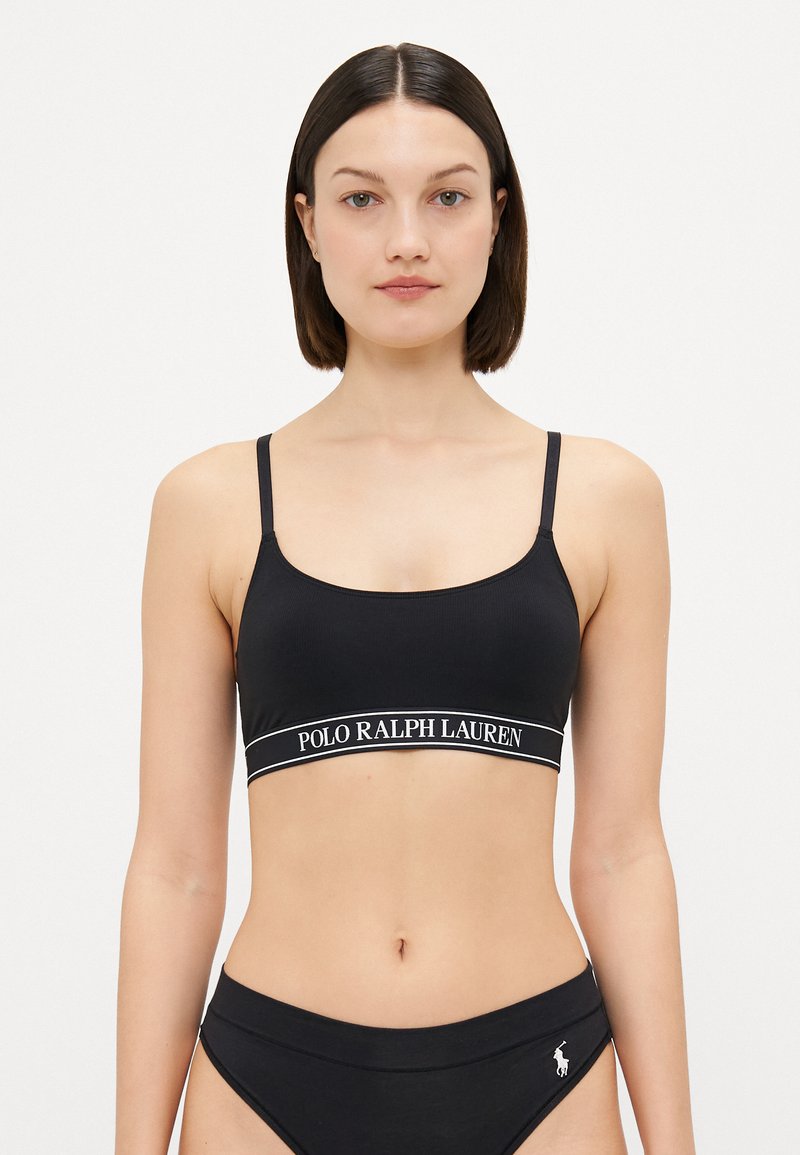 Melna bralette ar plānām siksniņām, ar baltu "POLO RALPH LAUREN" joslu. Matēta tekstūra un vienkāršs, pieguļošs dizains.