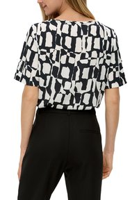 Korte mouwen blouse in zwart en wit met een abstract patroon. Zachte, lichte stof, ronde halslijn, comfortabele pasvorm, gelaagd detail aan de achterkant.