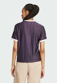 Paarse sportshirt met verticale strepen, korte mouwen en een witte kraag. Gemaakt van gladde stof, met een ontspannen pasvorm en minimale details.