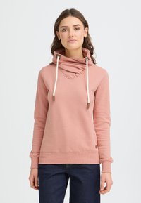 Sudadera con capucha de color rosa claro con cuello tipo pañuelo y cordón ajustable, que presenta una costura en forma de V en el pecho y puños y dobladillo acanalados.